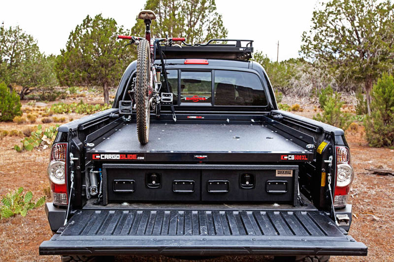 the rear of Toyota Tacoma with a TruckVault in the bed. There is also a mountain bike on top of the TruckVault.