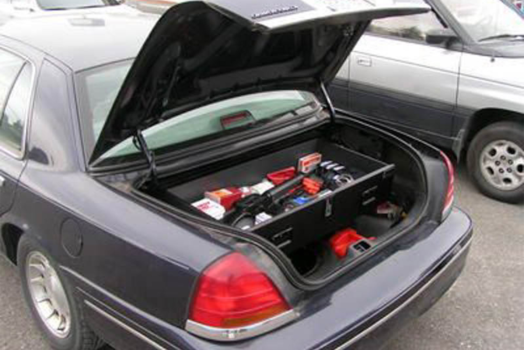 A navy Ford Crown Victoria police vehicle with a TruckVault in the trunk.