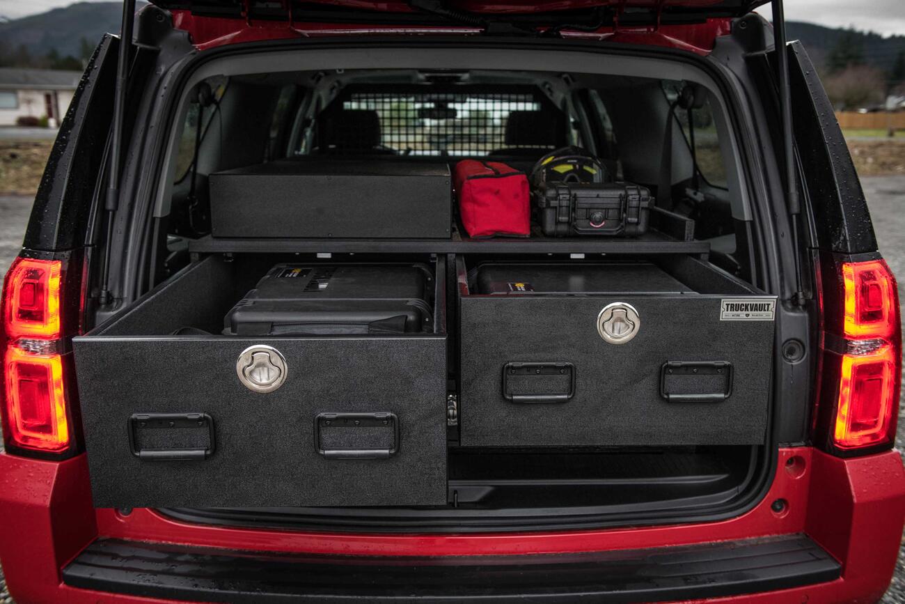 Two open TruckVault drawers in the back of a red Chevy Suburban. 