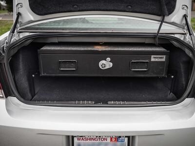 A silver Chevy Impala with an Elevated TruckVault in the trunk space.