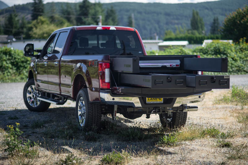 A red Ford F-250 with a custom TruckVault in the bed.