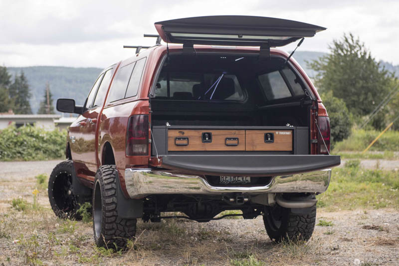 A red Ram 1500 with a TruckVault and wood grain drawer faces.