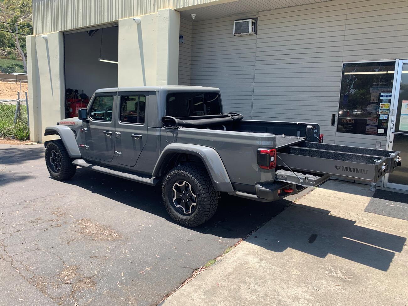 A Jeep Gladiator with a TruckVault storage system with the drawers pulled out.