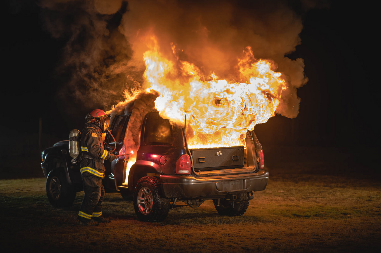 Durango burning with TruckVault installed back hatch firefighter igniting vehicle for product testing