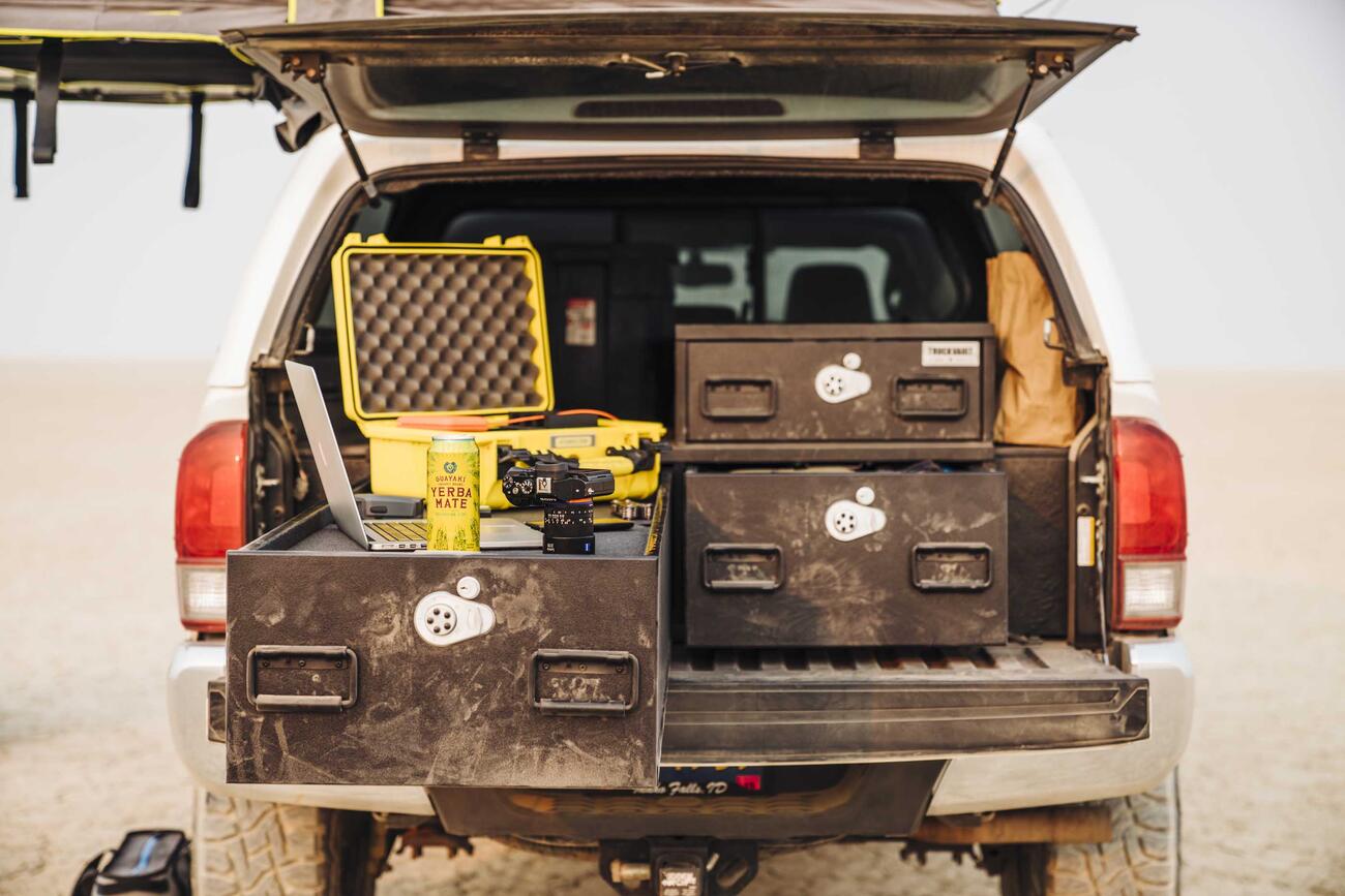 A truck parked in the desert with a custom TruckVault in the bed. 