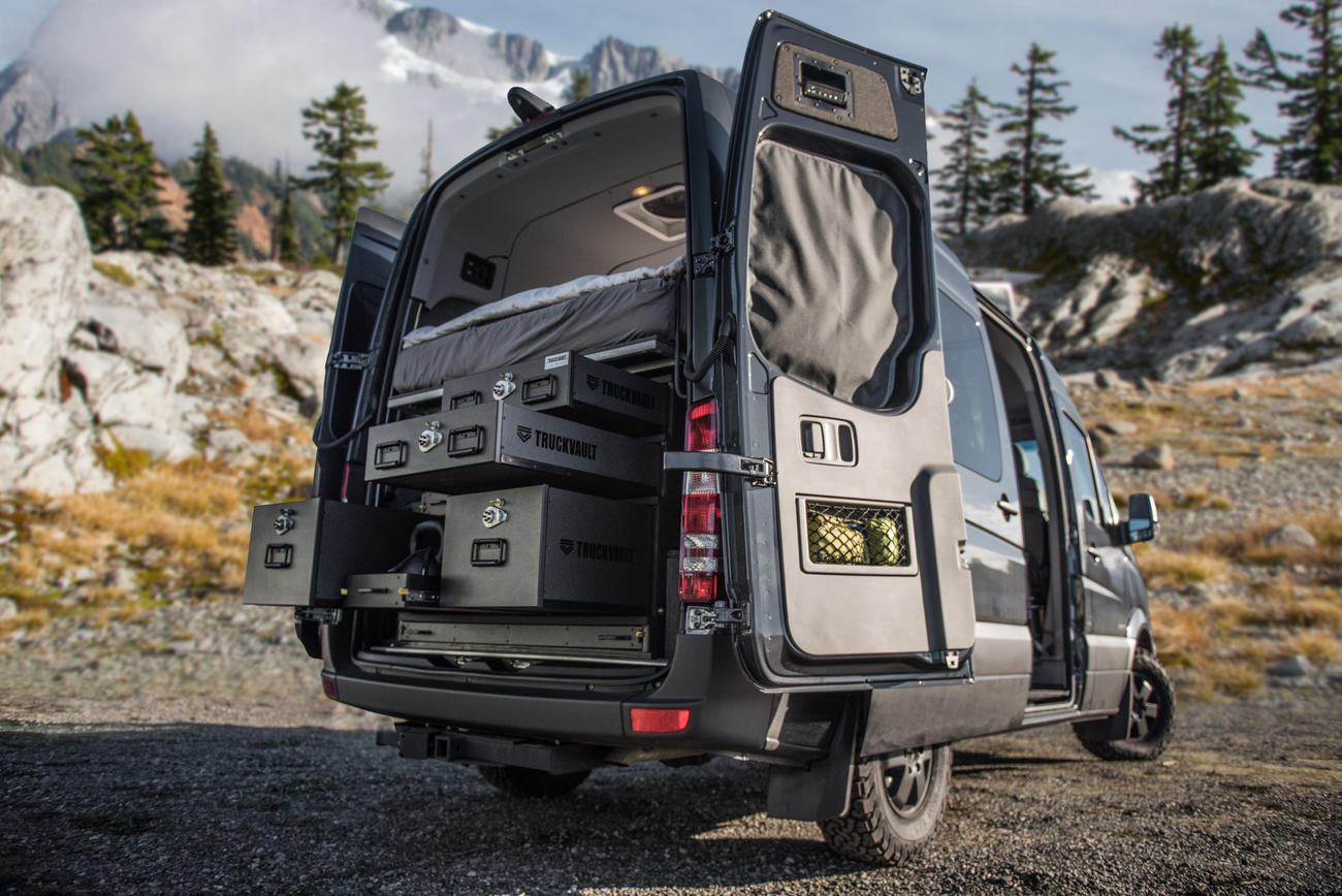 A black Mercedes Sprinter with a customized TruckVault storage setup.