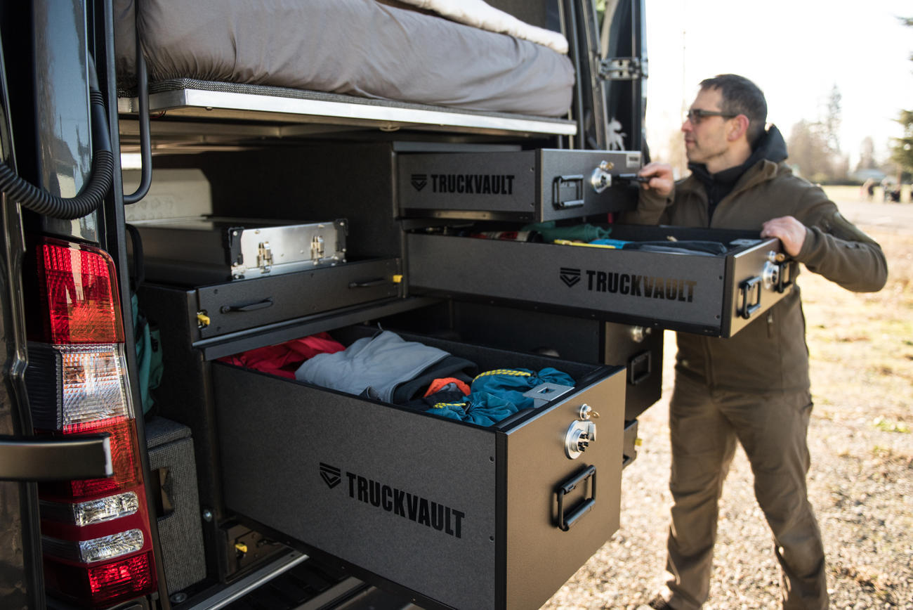 A man pulling his TruckVault drawer out to reach his gear.