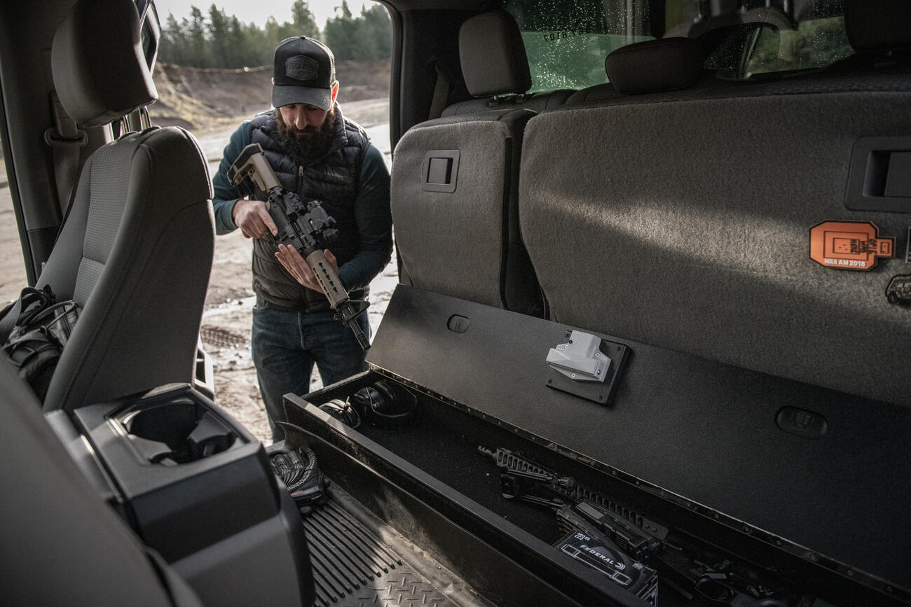 A man checking his rifle before he places it into a SeatVault.