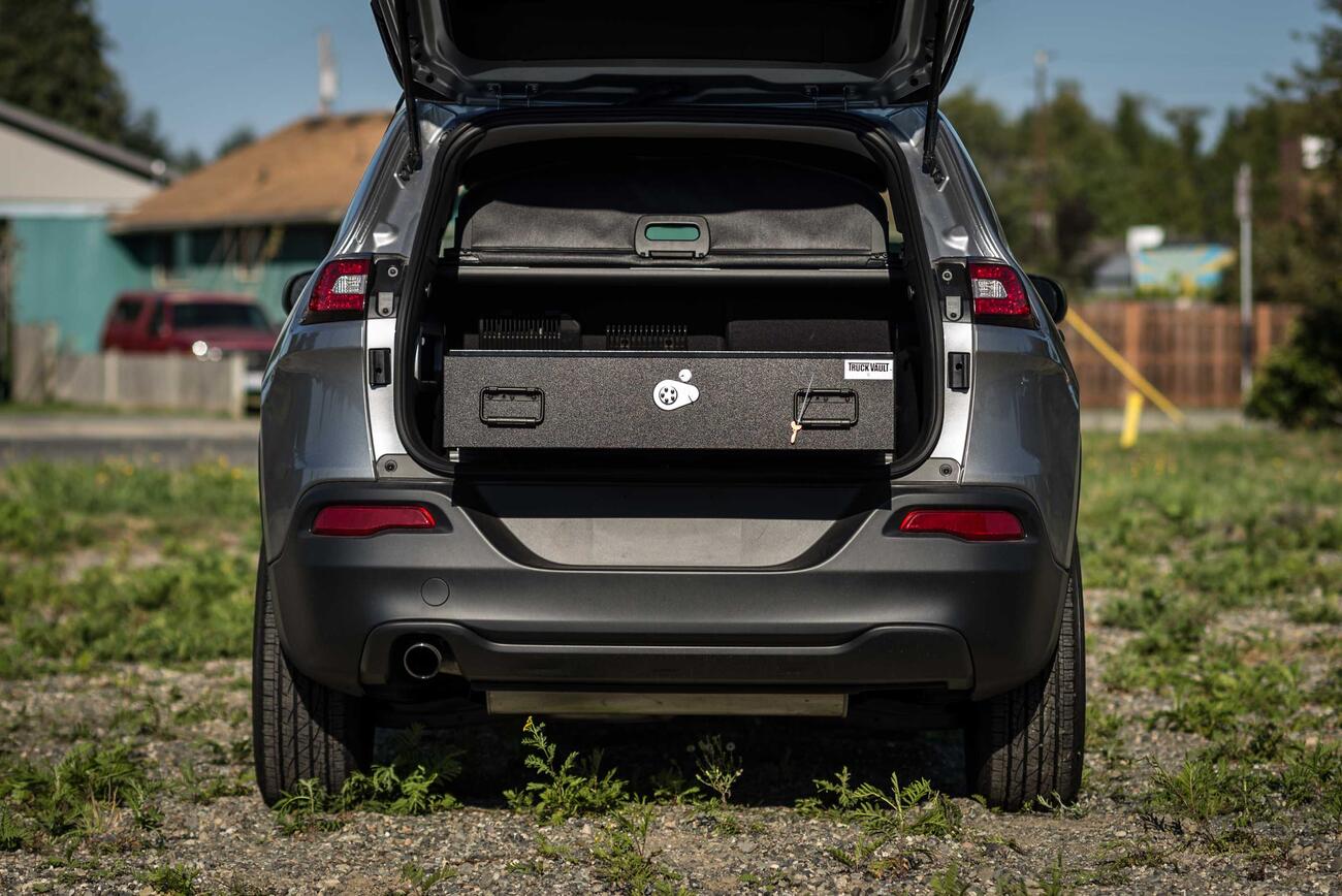 The back of a gray, open Jeep Grand Cherokee with an open TruckVault in the back.