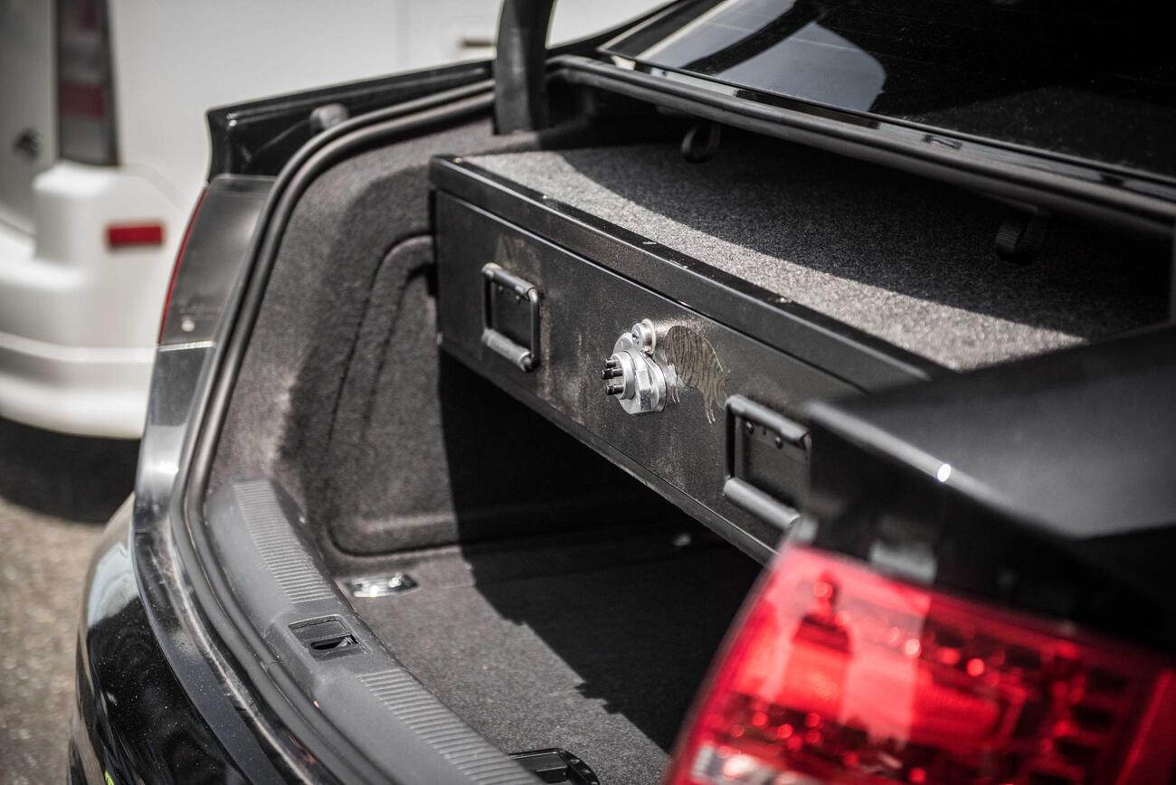 A black Audi sedan with a TruckVault in the cargo area.