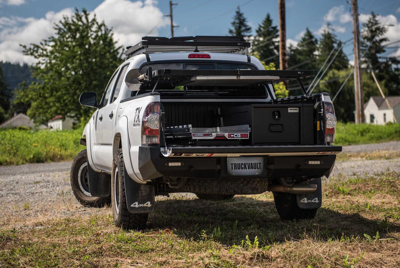 PickupSeries_All-WeatherLine_StandardOffset_2012_Chevy_Silverado_DonFenton3.jpg A white truck with a TruckVault and a cargo slide in the bed.