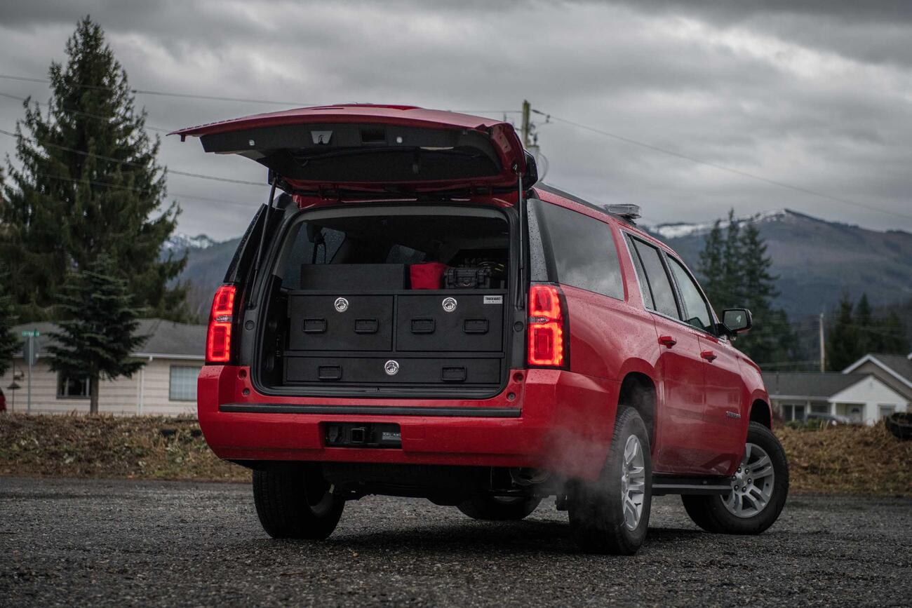 The back of a red, open Chevy Suburban with a custom TruckVault.