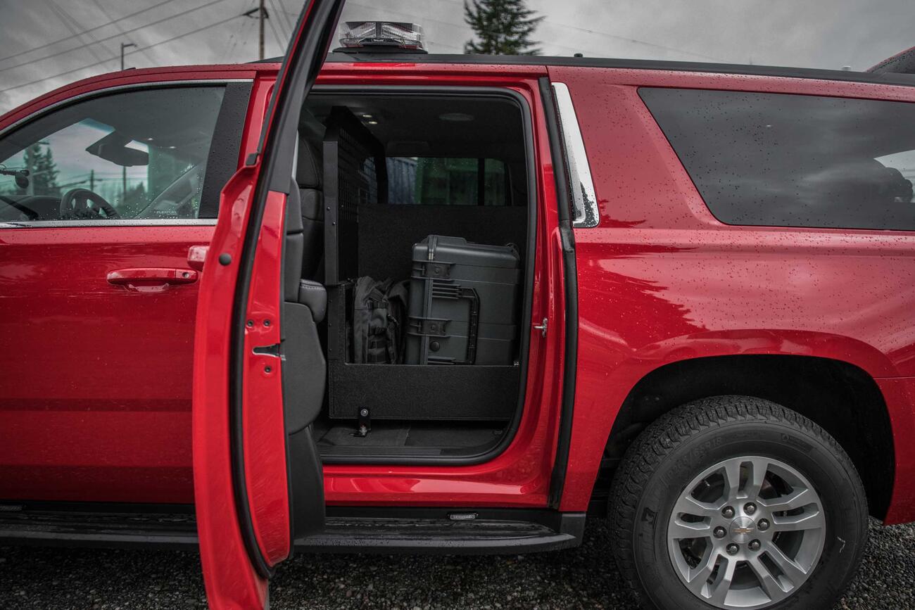 A view inside the read door of a red, fire department Chevy Suburban with a Custom TruckVault inside.