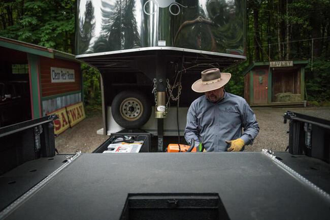 A man taking his gear out of a gooseneck TruckVault storage system.