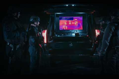 SWAT members gather around infrared imaging displayed on a TruckVault Drone Responder 9 during a training session