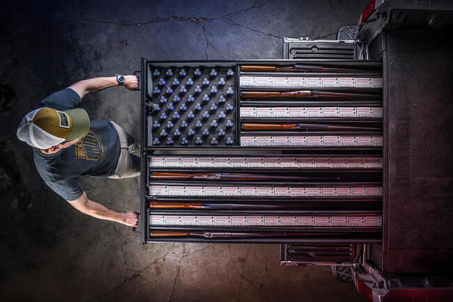 A TruckVault being pulled out of the bed of a pickup truck with an American flag design in the drawers.