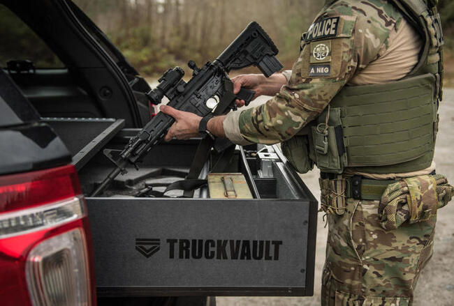 A law enforcement professional taking a firearm out of his TruckVault storage system.