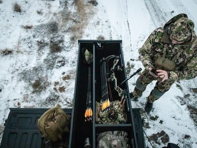 snowy day as outdoorsman reaches into extended drawers of half width TruckVault secure storage system for pickup truck