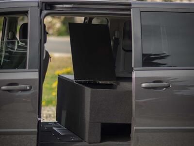 The side of a black Dodge Grand Caravan with a TruckVault inside.