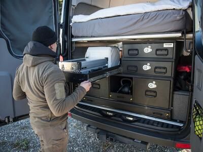 A man opening a custom TruckVault storage system in a Mercedes Sprinter van.