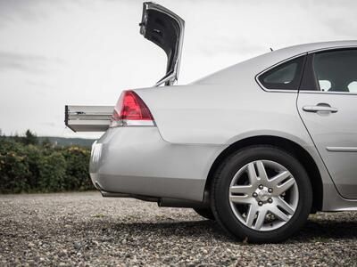 A silver Chevy Impala with an opened TruckVault in the trunk.