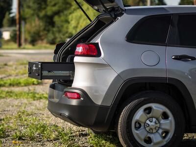 A Jeep Grand Cherokee parked with a TruckVault opening out of the rear.