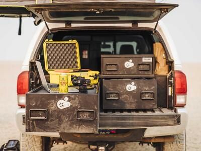 A truck parked in the desert with a custom TruckVault in the bed. 