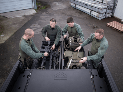 A swat team grabbing their guns and gear out an all weather TruckVault in a black F-150