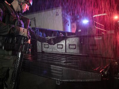 A member of a SWAT team opening an F-150's TruckVault in order to secure his weapon.