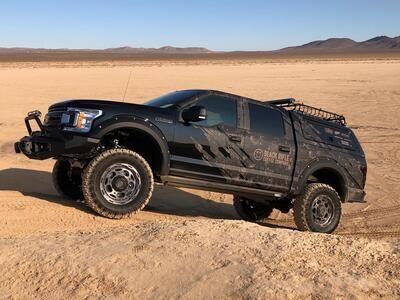 the Black Rifle Coffee Company truck driving up a sand dune in the desert.