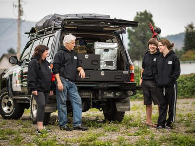 Family using a custom TruckVault storage system for overlanding. 