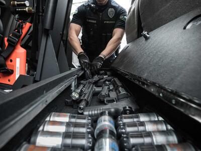 A police officer taking his gun out of his SeatVault.