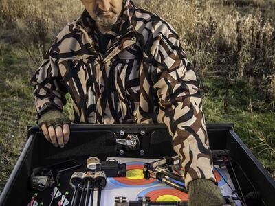 A hunter taking his bow out of his Ford F-150 All-Weather TruckVault.