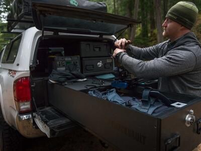 Andy Best taking his camera gear out of a TruckVault in the back of his Toyota Tacoma.