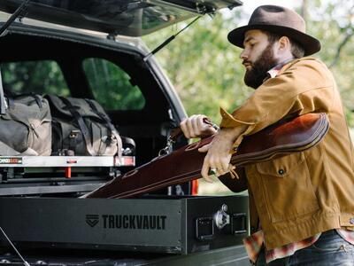 A man placing his shotgun into his TruckVault