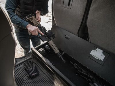 A man grabbing a rifle out of a SeatVault.