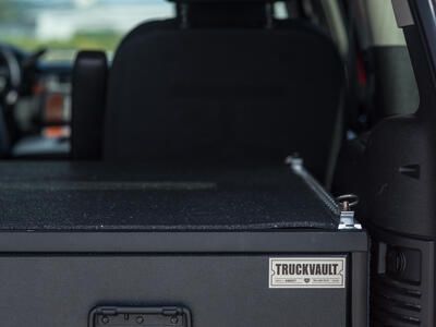 Rubber mat and tie down rail shown on top of a TruckVault secure storage drawer system