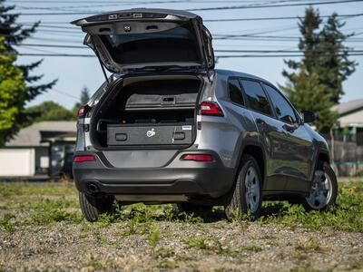 A Truckvault in the back of a Gray Jeep Grand Cherokee.