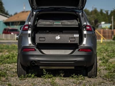 The back of a gray, open Jeep Grand Cherokee with an open TruckVault in the back.