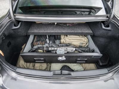 A Dodge Charger with an elevated TruckVault in the cargo space. The TruckVault is full of a gun and ammunition.