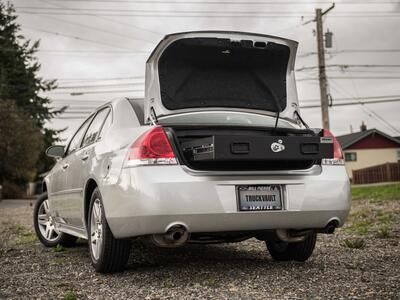 A Chevy Impala with an open, elevated TruckVault in the cargo area.