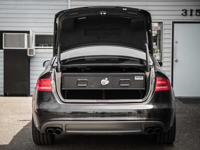 A gray Audi sedan with an elevated TruckVault in the cargo area.