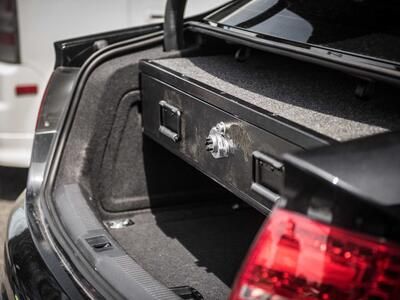 A black Audi sedan with a TruckVault in the cargo area.