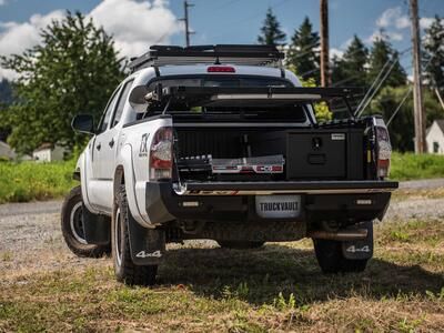 A white truck with a TruckVault and a cargo slide in the bed.