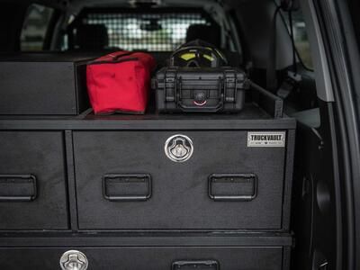 A custom TruckVault with boxes on top. All inside of a red Chevy Suburban.